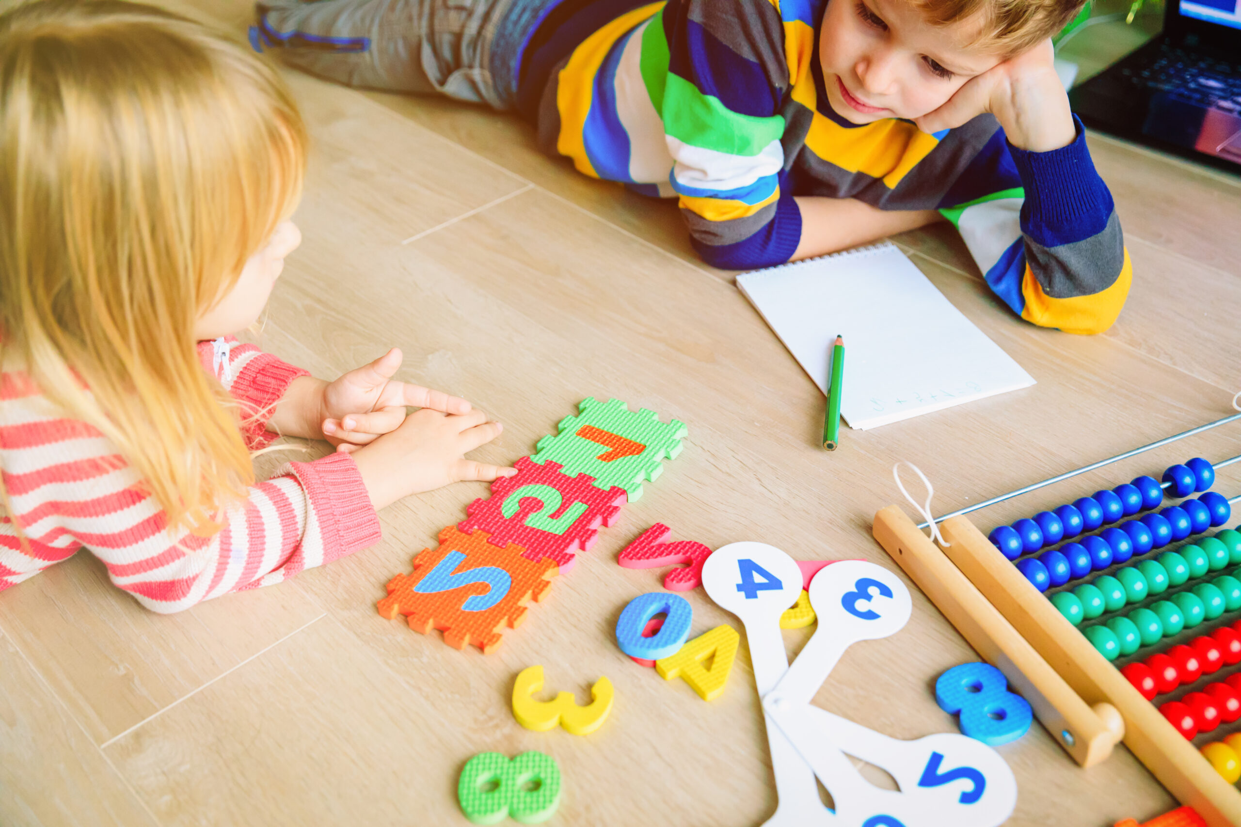 kids lying on floor doing number activities