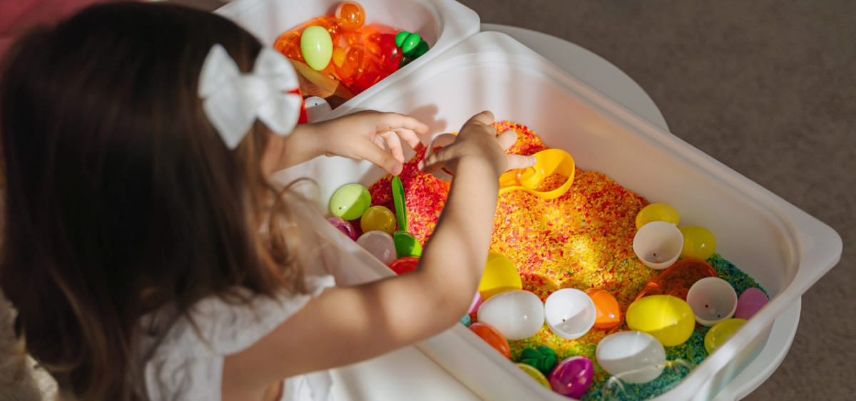 Preschooler playing in a summer sensory bin. 