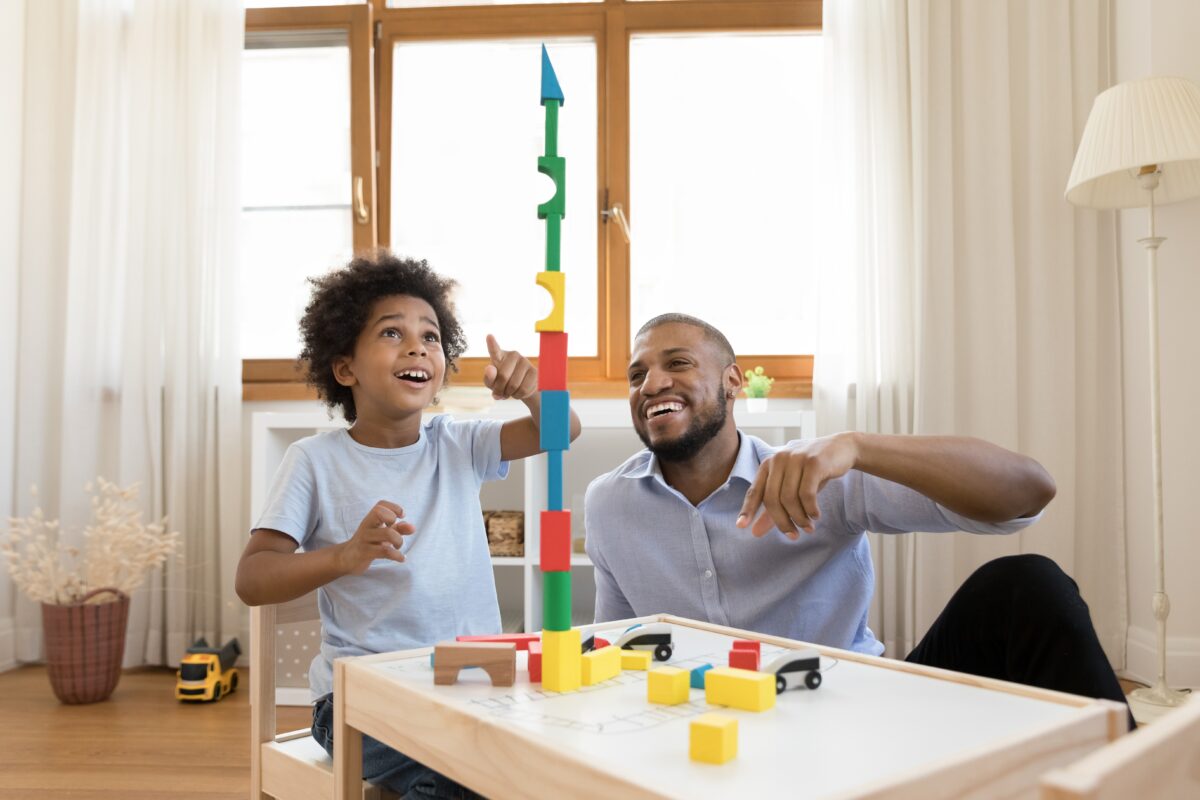 Father and son measuring and building blocks together to learn more about math. 