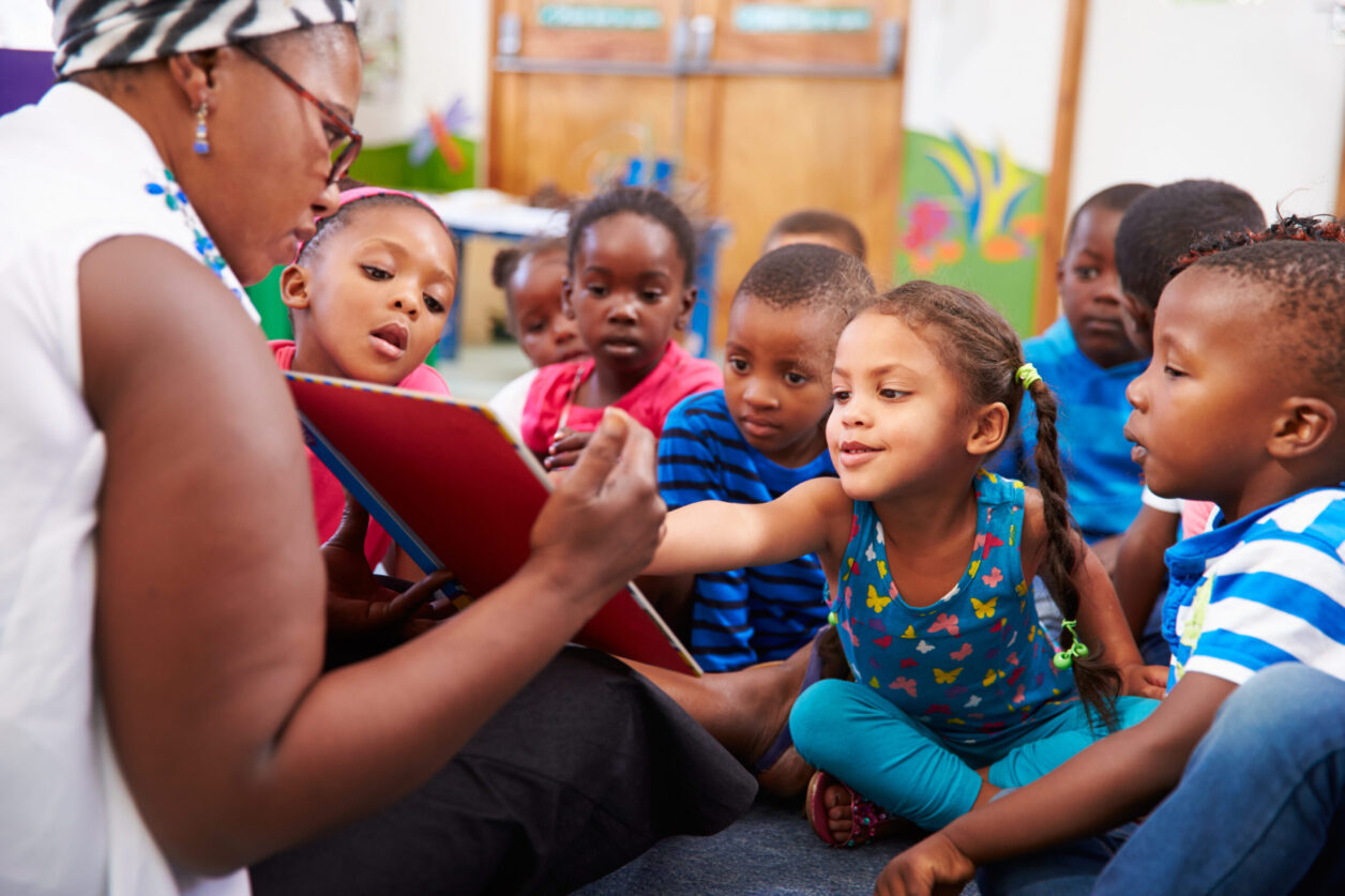 Teacher reading a book to preschoolers.