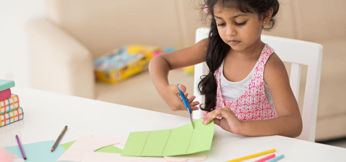 preschool girl cutting and counting paper strips
