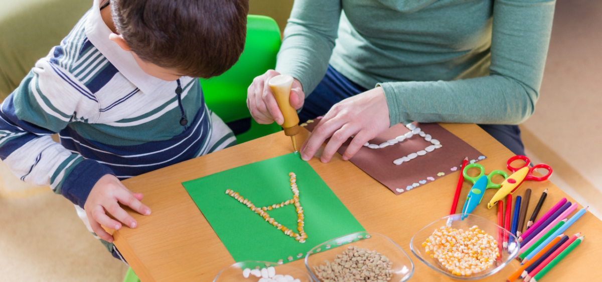 Boy and mother making a letter craft together. 