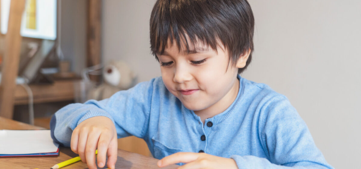 Boy learning sight words while sitting at a table. 