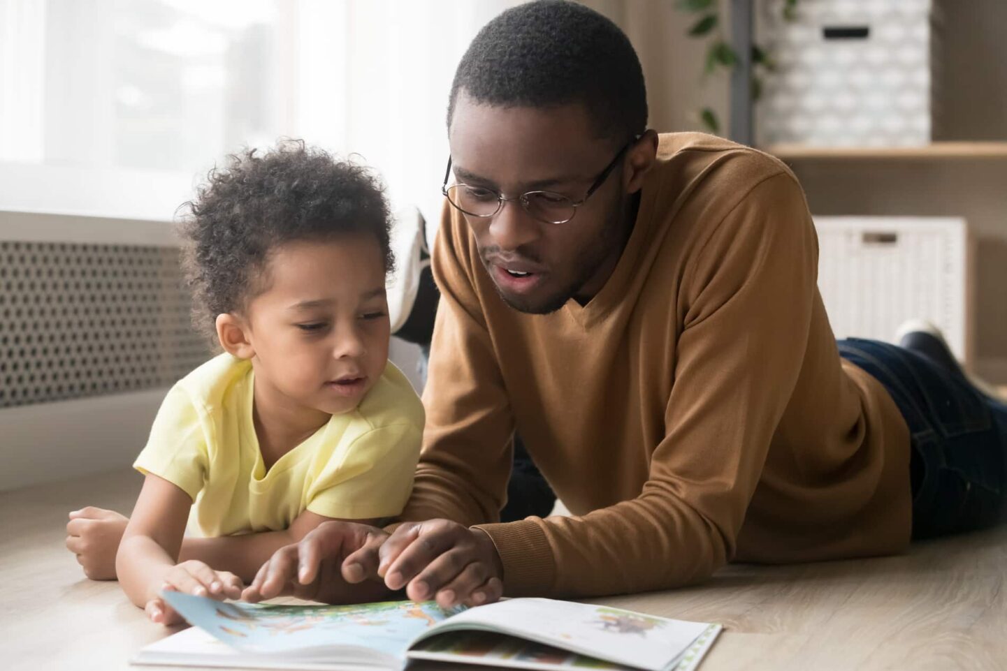 Father and son reading an alphabet book together. 