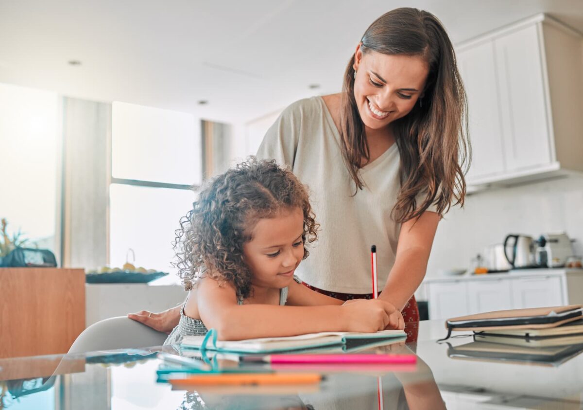 Daughter and mother writing sight words in a journal. 