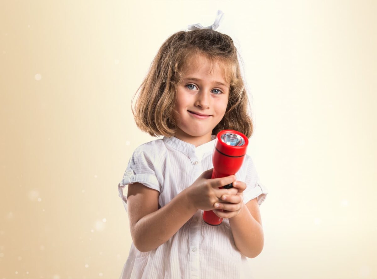 1st grade girl holding a flashlight. 