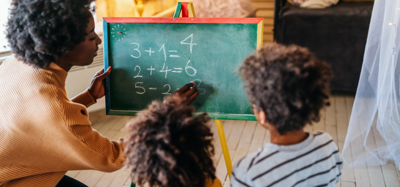 Mother teaching her two children how to do simple addition. 