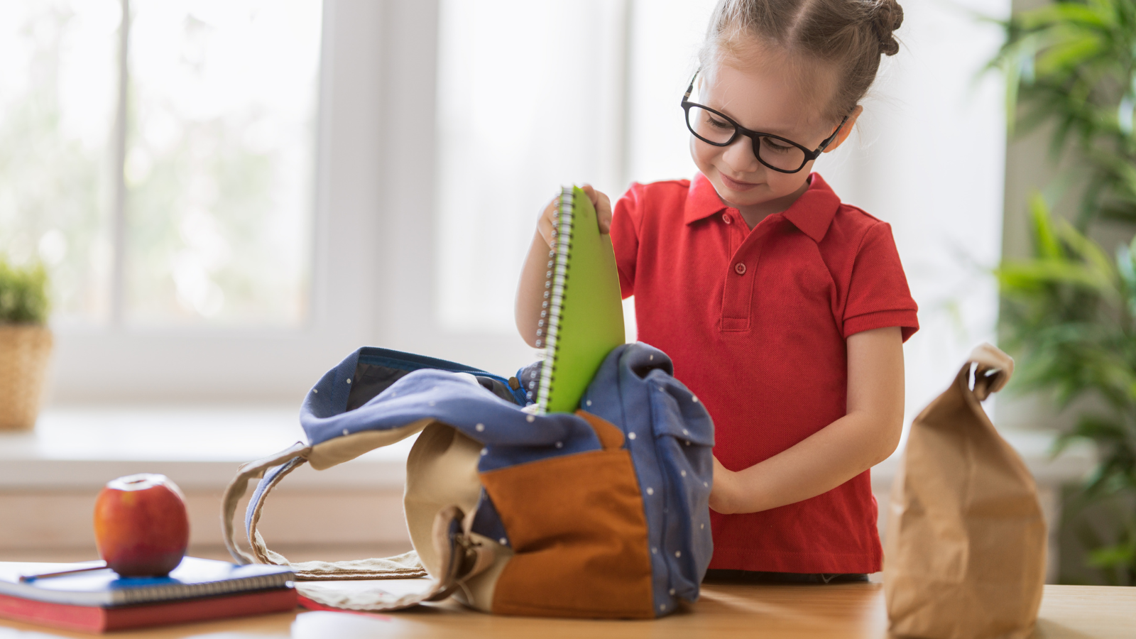 Child organizing her backpack for school.