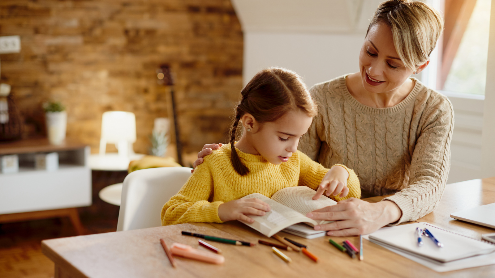 Mother helping her daughter with her reading skills. 