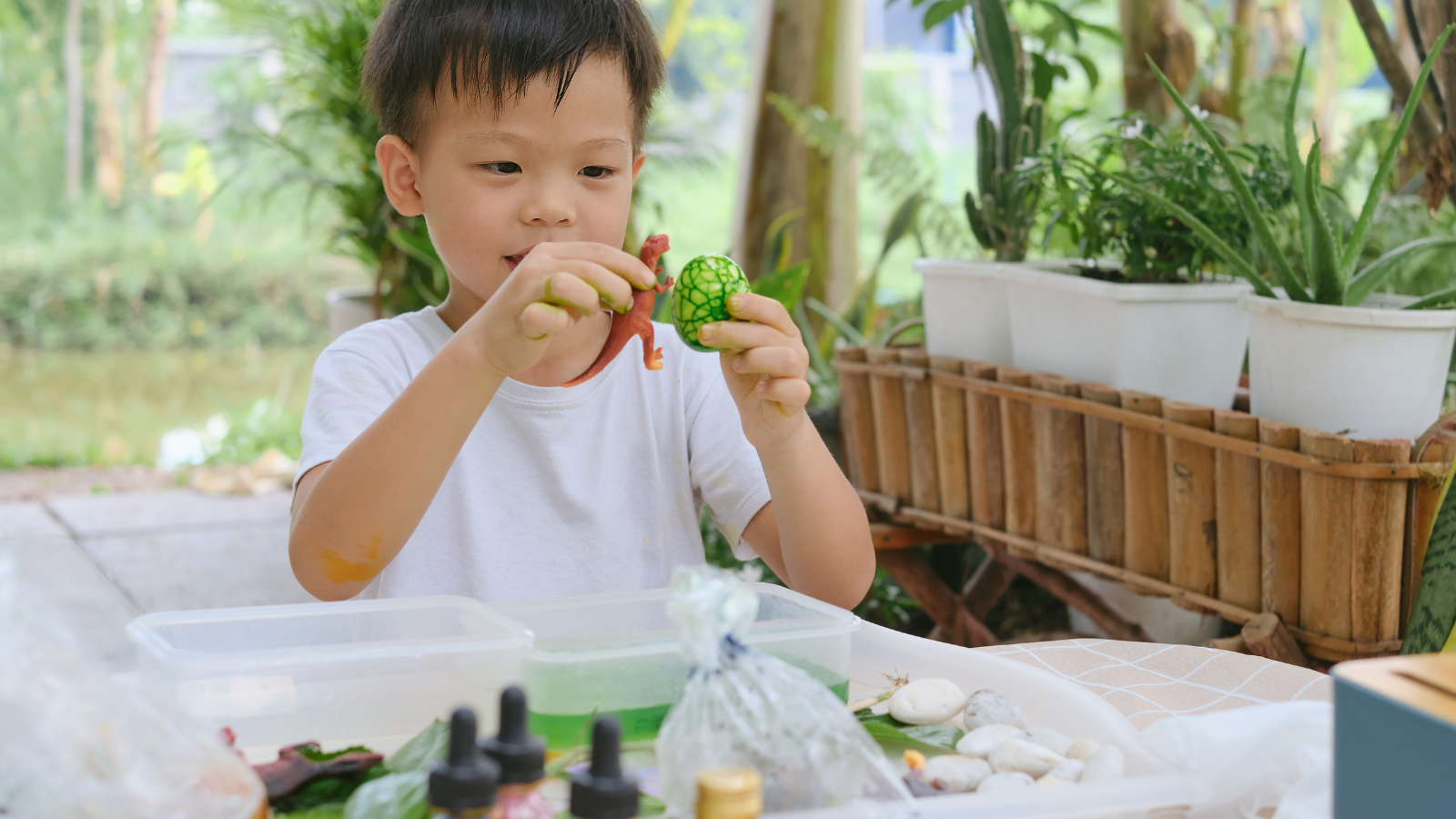 A boy playing in a sensory bin. 