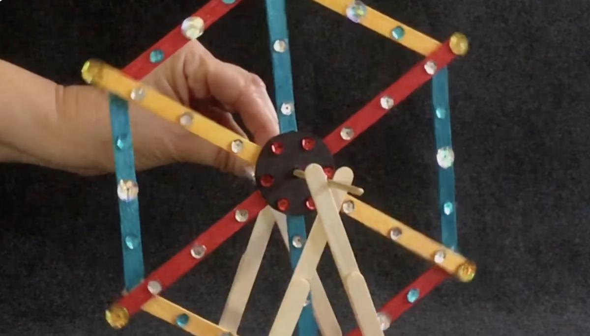 Decorating a fun popsicle stick Ferris Wheel STEM activity craft by ABCmouse. 