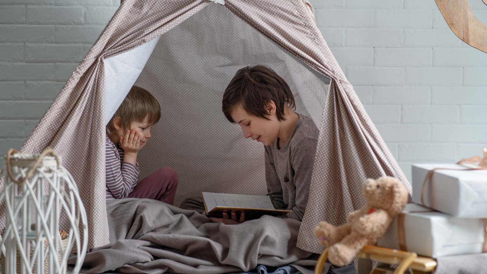 Two children reading together in a quiet reading nook. 