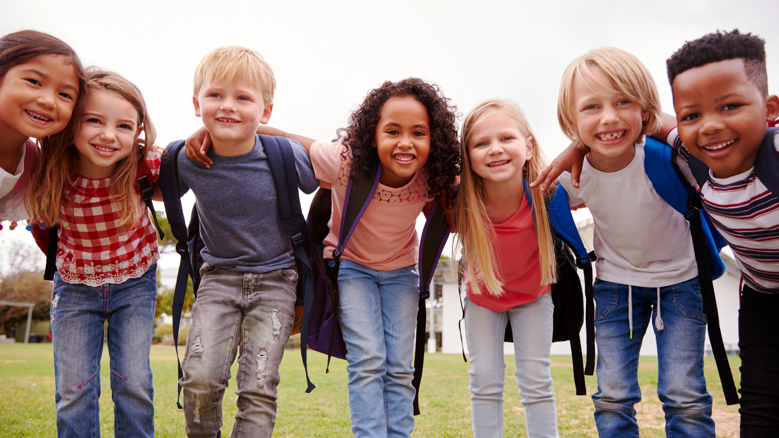 Grade school friends with arms over the shoulders in show of love and acceptance.