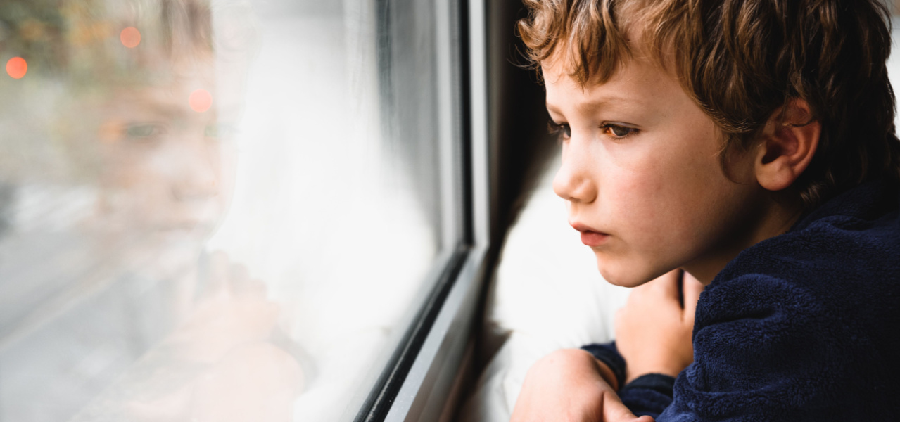 Sad boy looking out the window. 