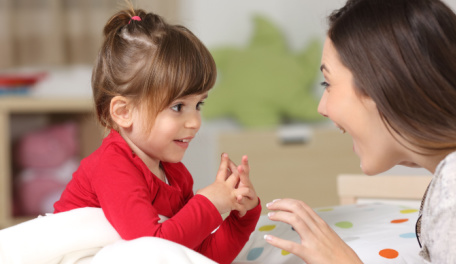 Mother happily talking with her preschool age daughter. 