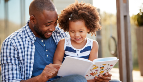 Father reading with his preschool age daughter. 