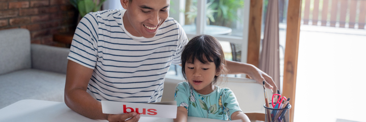 A child and her father learning how to read sight words. 