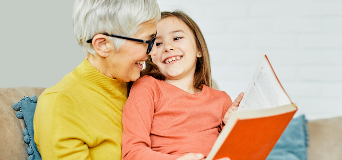 A grandmother and granddaughter sitting together to read.