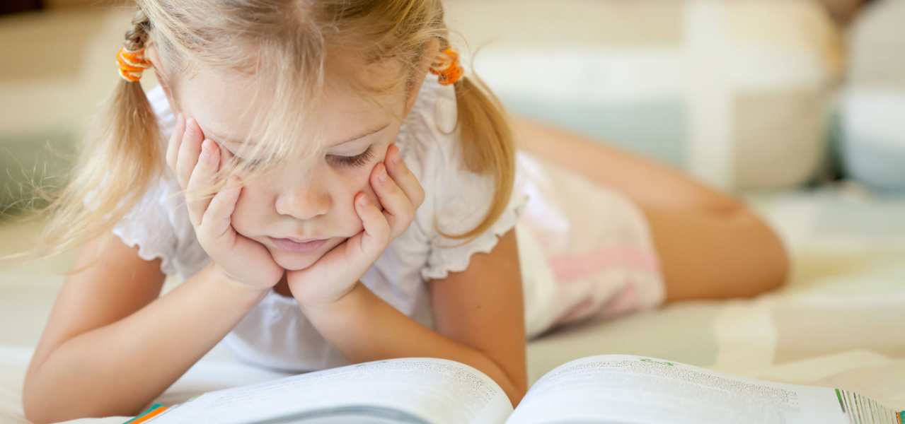 First grade child reading a book. 