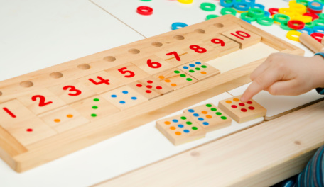 Child practicing adding and numbers with manipulatives. 