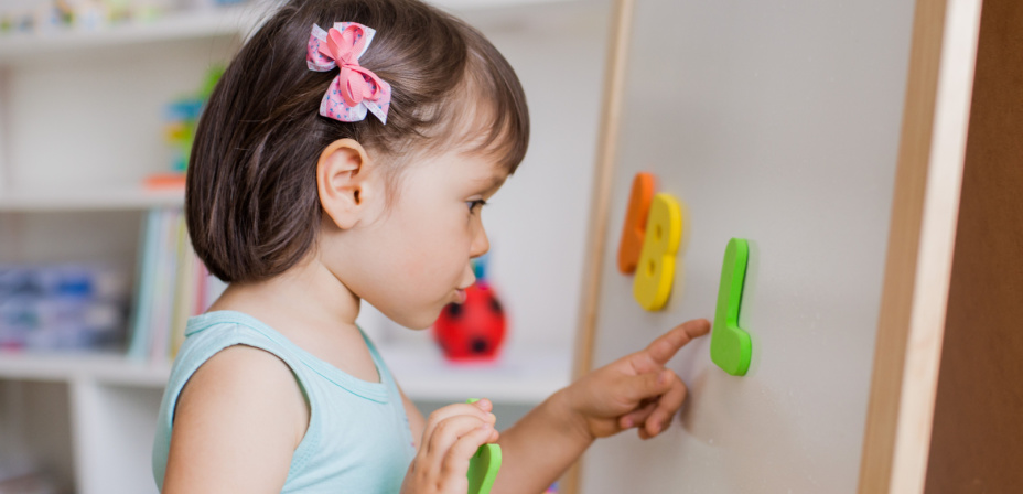 A child playing with magnetic letters. 