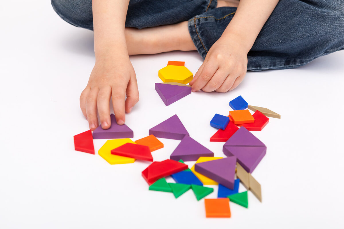 Child sorting shapes for learning math concepts. 