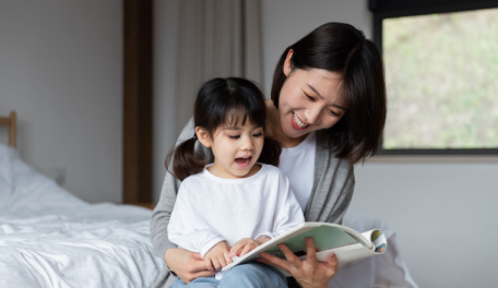 A mother reading to her daughter. 