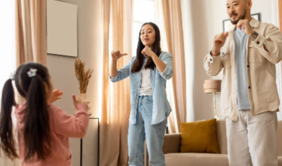 Parents and child singing together using hand signs. 