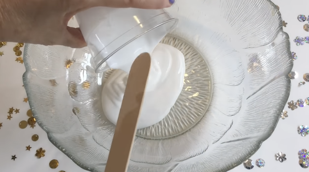 A large bowl of glue mixing with a popsicle stick. 