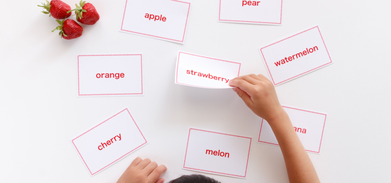 A child looking at cards with different words written on them. 