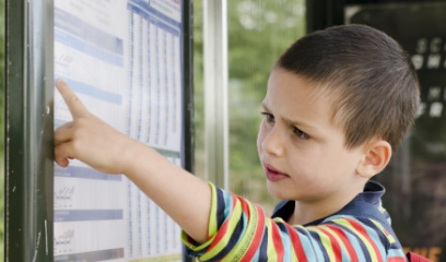 A boy pointing to a chart wondering what it is. 