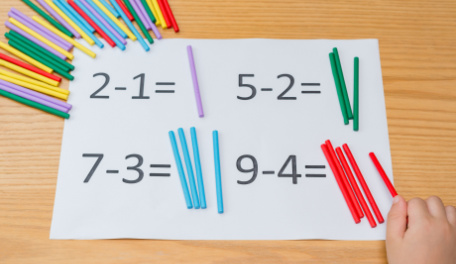 Math problems on a sheet of paper and straws. 
