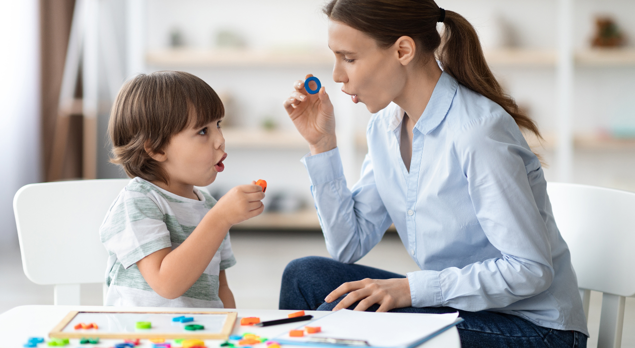 Mother and son learning letter sounds by making the letter o sound with their mouth. 