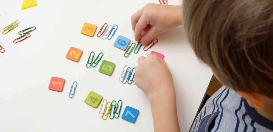 A child counting with colorful paper clips. 