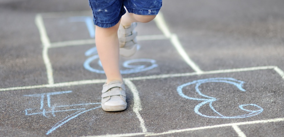 A child playing hopscotch to learn numbers. 