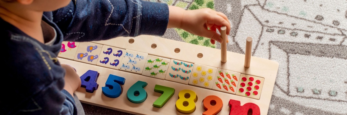 A child playing with a number peg board. 