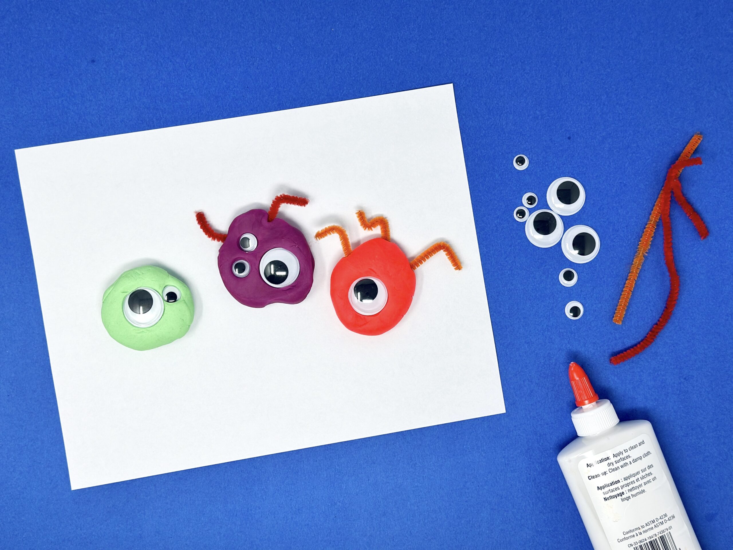 Colorful letter M monsters made with paint, googly eyes, and pipe cleaners.