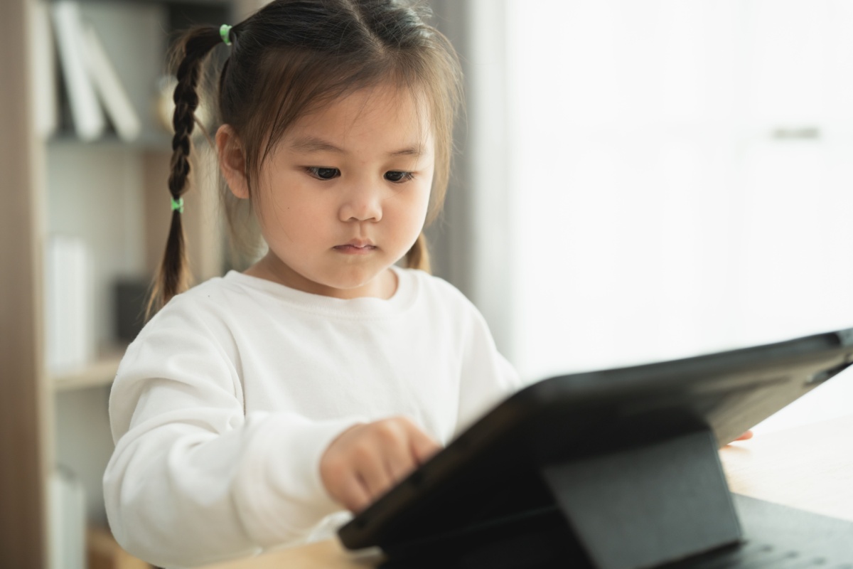 A young girl playing ABCmouse on an I-Pad. 