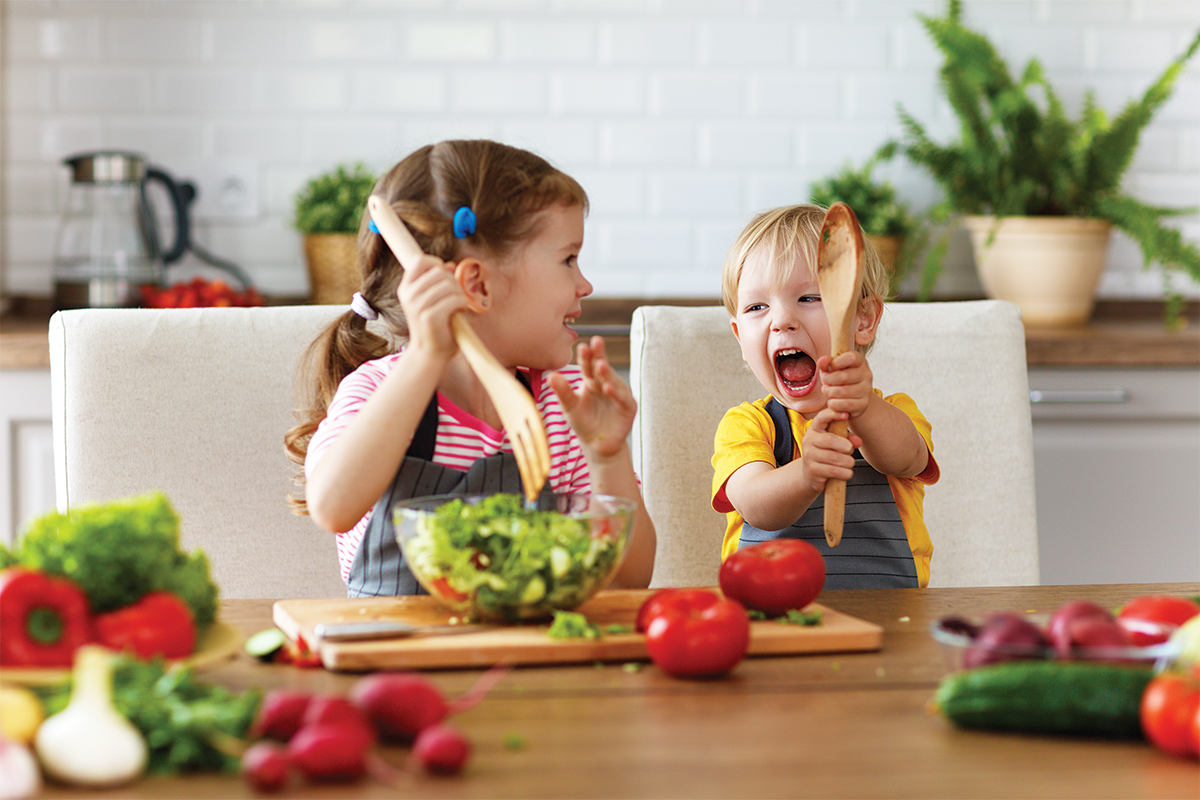 Young children making a salad bar  for a fun summer activity. 