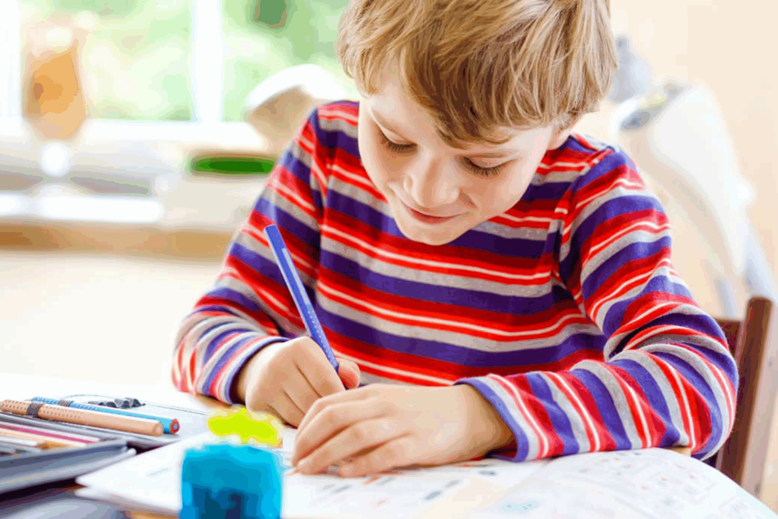 A young boy writing summer themed poems. 
