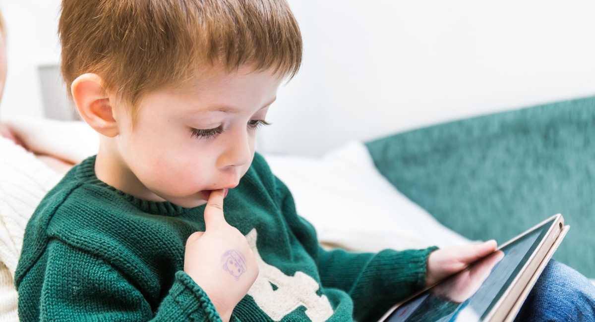 A young boy playing ABCmouse on his i-pad. 