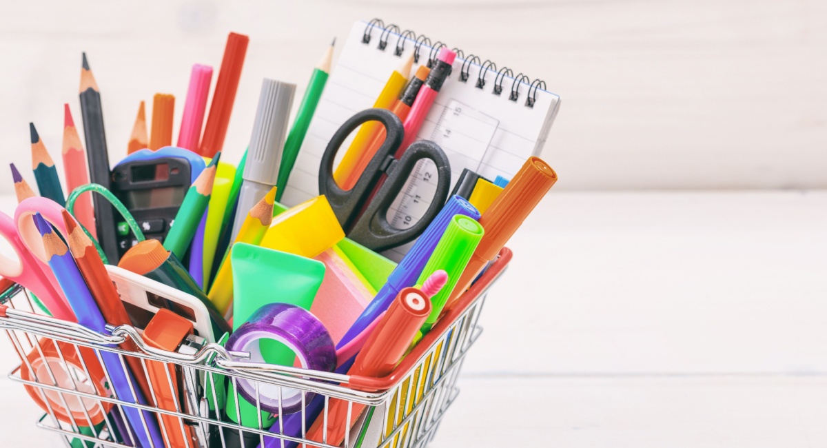A white basket full of colorful school supplies. 