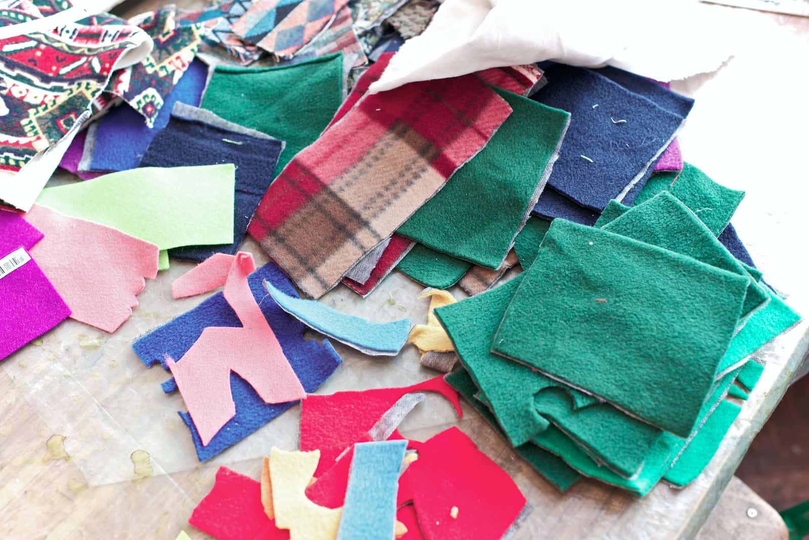 A pile of loose fabrics of different textures and sizes. 