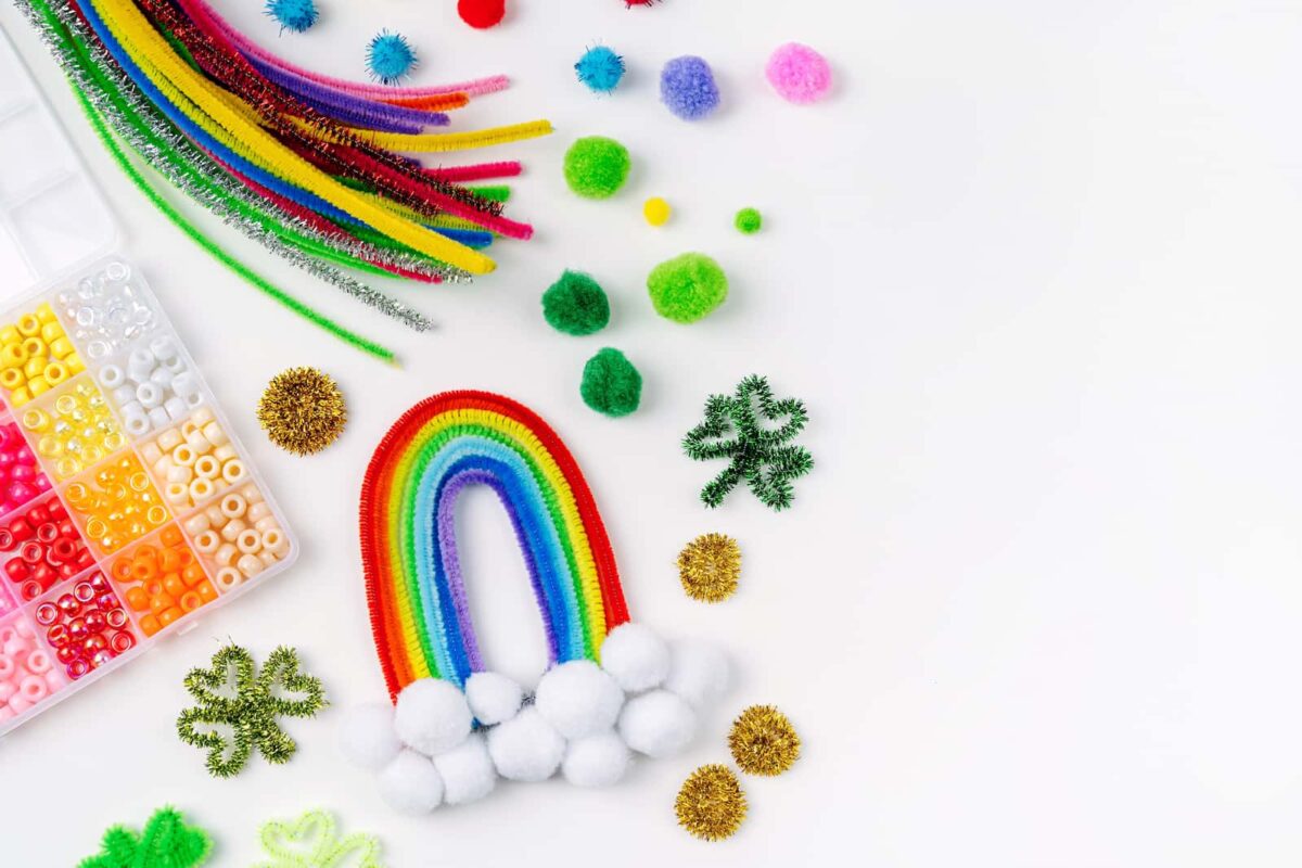 A colorful rainbow of pipe cleaners sitting next to a box of beads. 