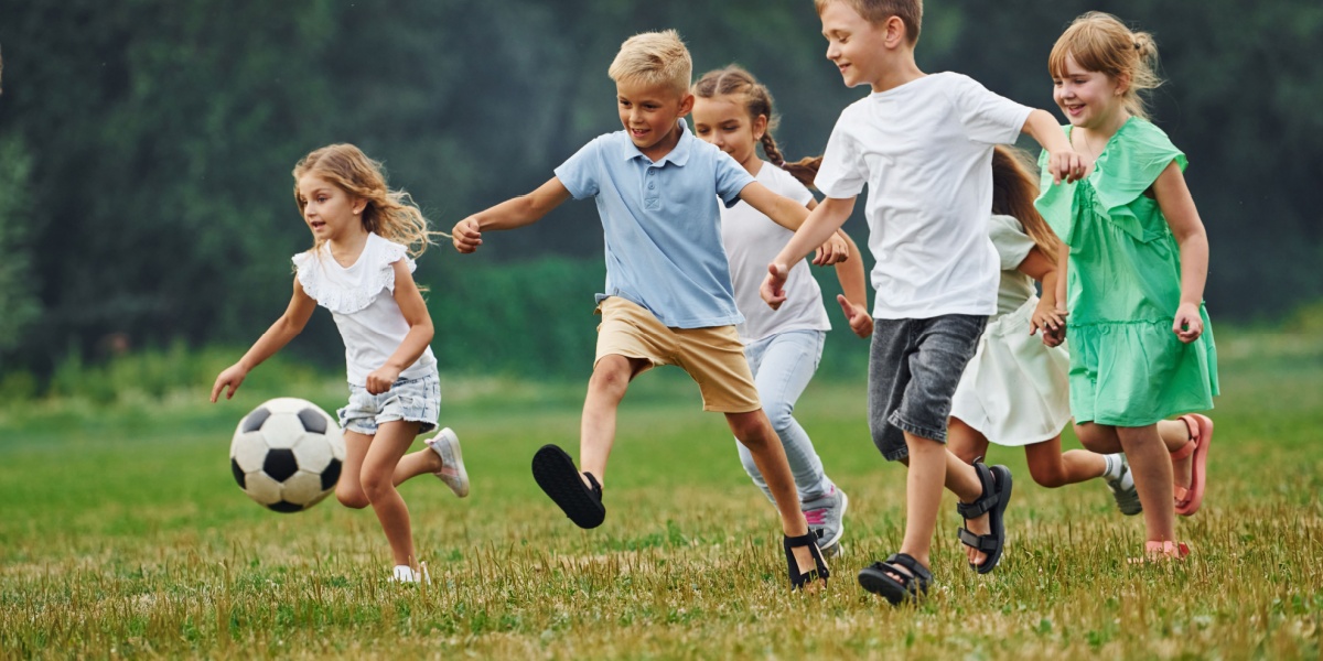 A young group of kids playing soccer in a field 