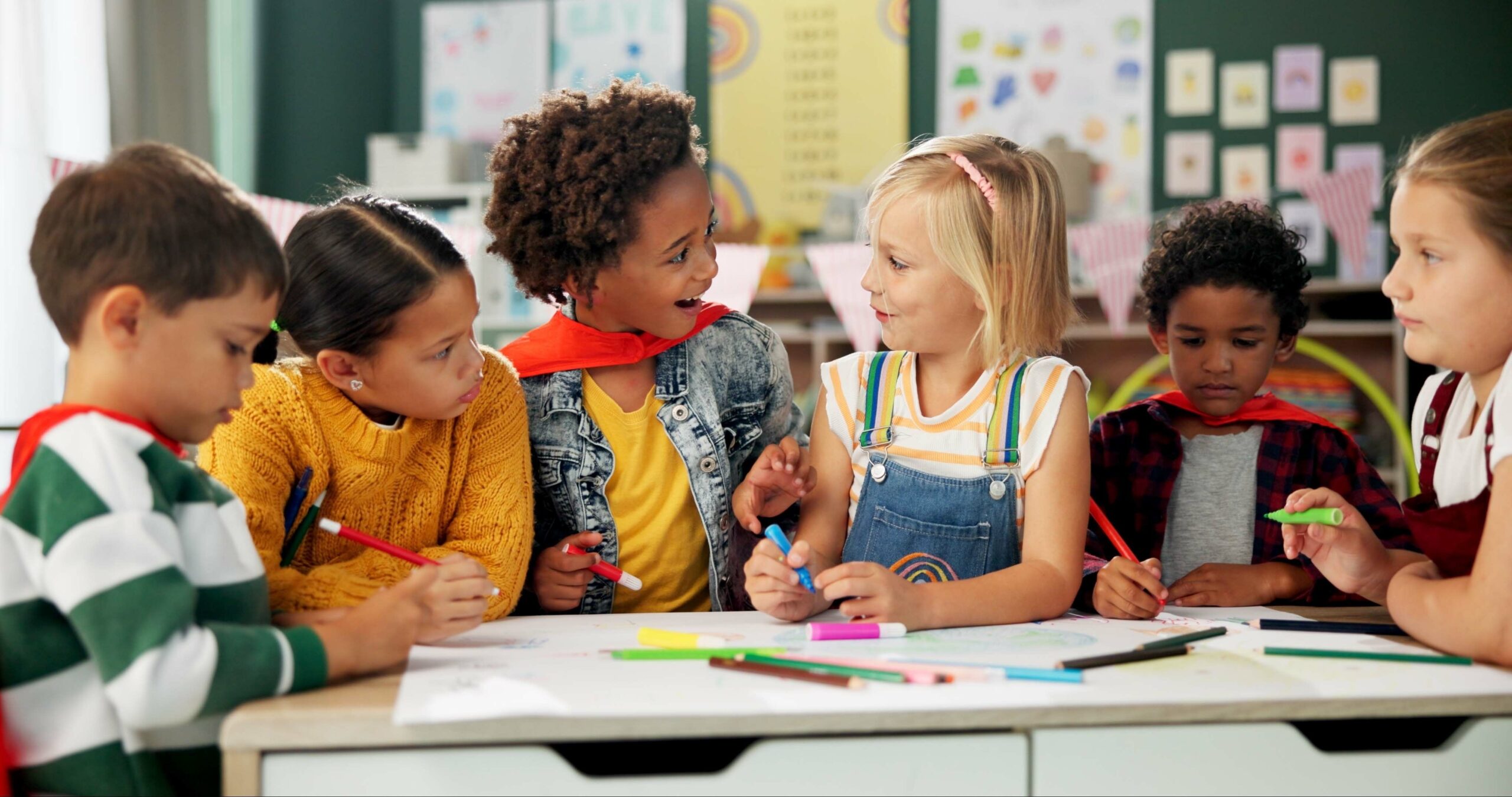 A group of kids doing crafts together in a classroom. 