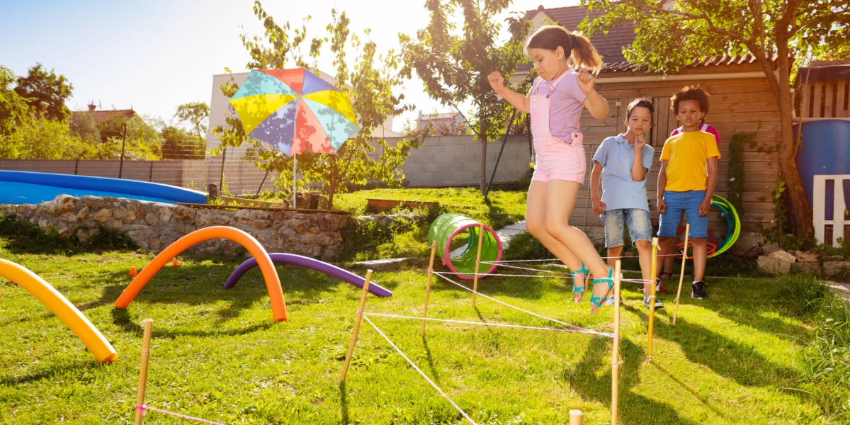 Kids playing in a homemade obstacle course in the yard. 