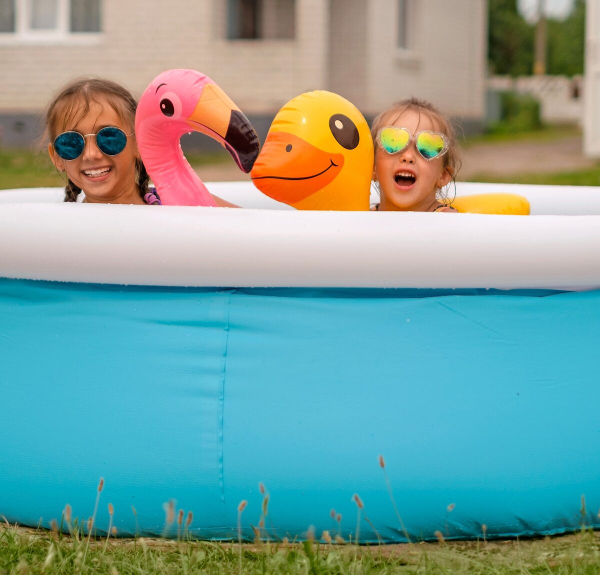 Two young girls in a kiddy pool playing together for summer fun sensory! 
