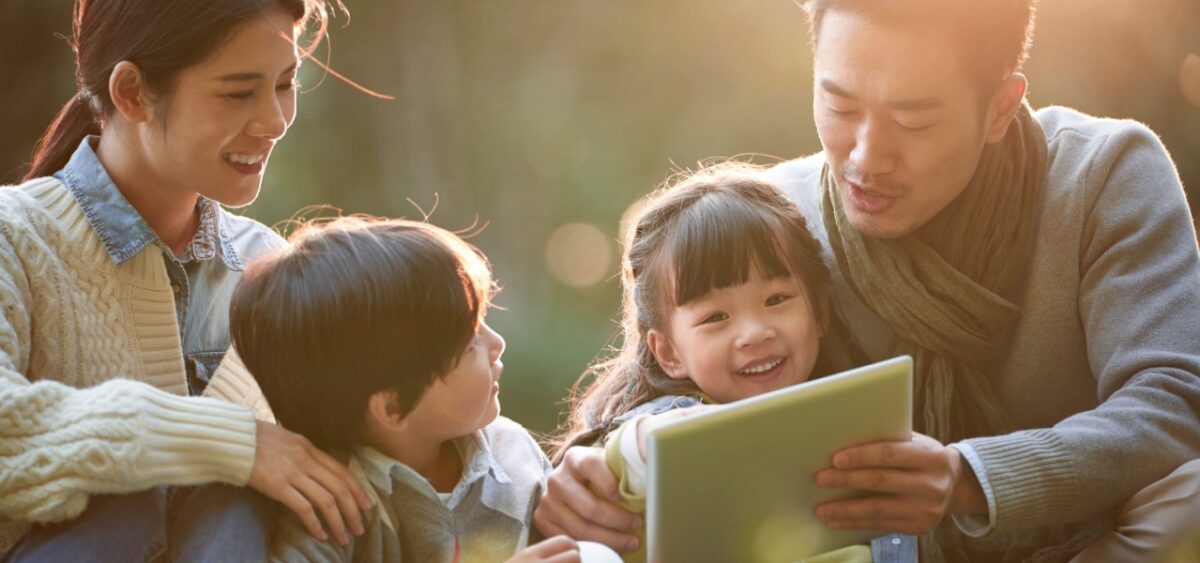 A family sitting together reading Thanksgiving themed books. 