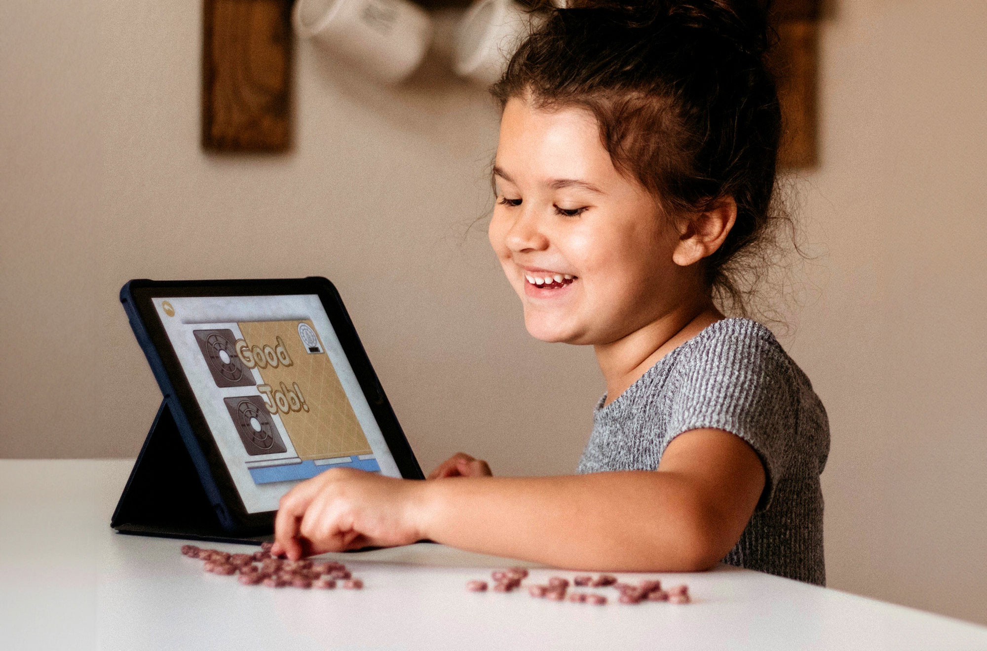 Cute little girl looking at an i-pad with the ABCmouse app playing on it. 